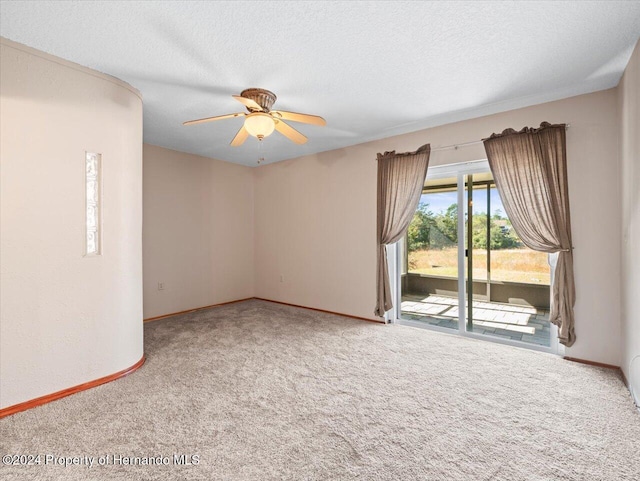 carpeted empty room featuring ceiling fan and a textured ceiling