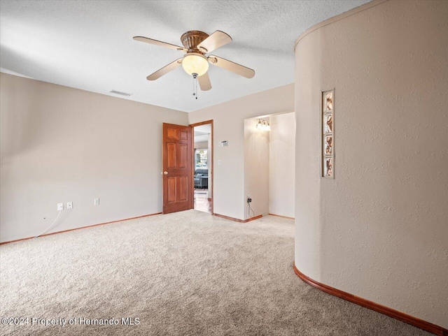 carpeted spare room featuring a textured ceiling and ceiling fan