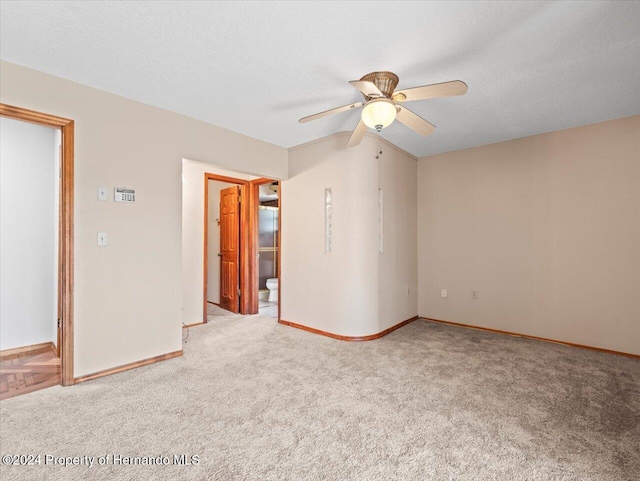 carpeted empty room featuring ceiling fan and a textured ceiling