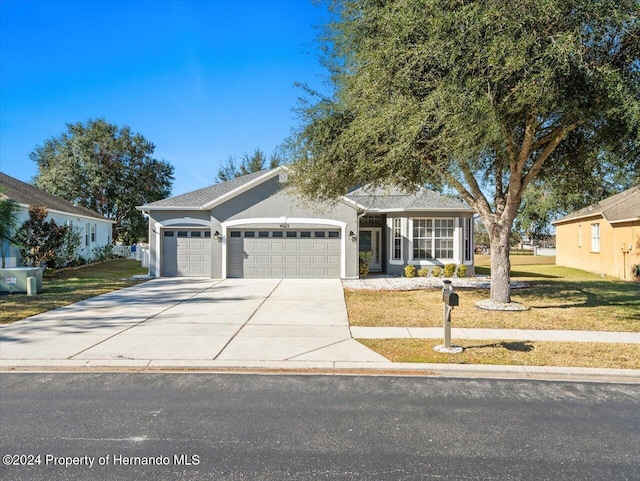 view of front of home with a front yard and a garage