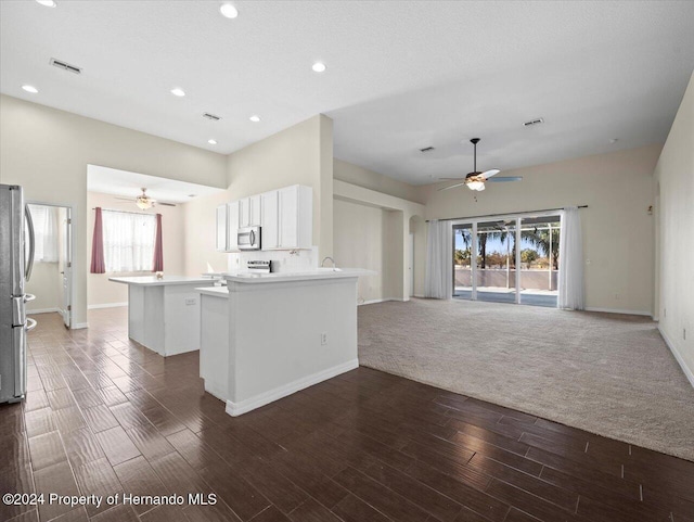 kitchen with a center island, dark hardwood / wood-style flooring, kitchen peninsula, white cabinets, and appliances with stainless steel finishes