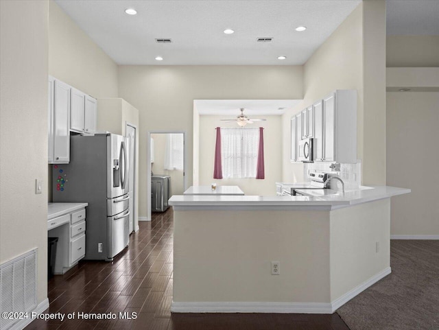 kitchen featuring kitchen peninsula, appliances with stainless steel finishes, dark hardwood / wood-style floors, and white cabinetry