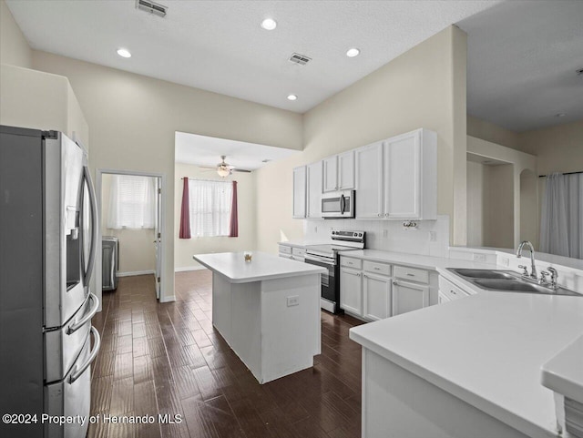 kitchen featuring a center island, dark wood-type flooring, white cabinets, sink, and stainless steel appliances