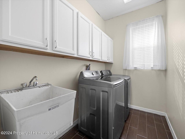 washroom featuring washer and clothes dryer, sink, cabinets, and dark wood-type flooring