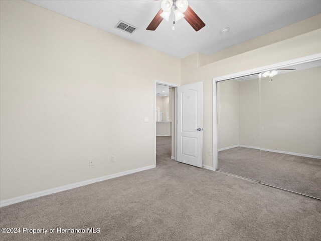 unfurnished bedroom featuring ceiling fan, carpet floors, and a closet