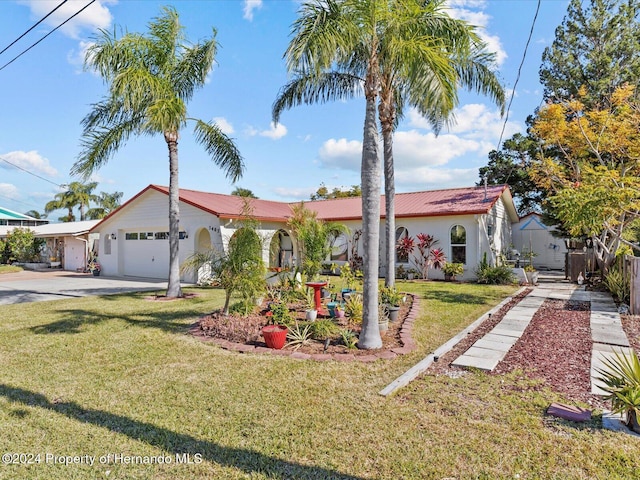 mediterranean / spanish home featuring a garage and a front lawn