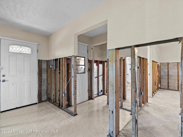 foyer entrance with a textured ceiling