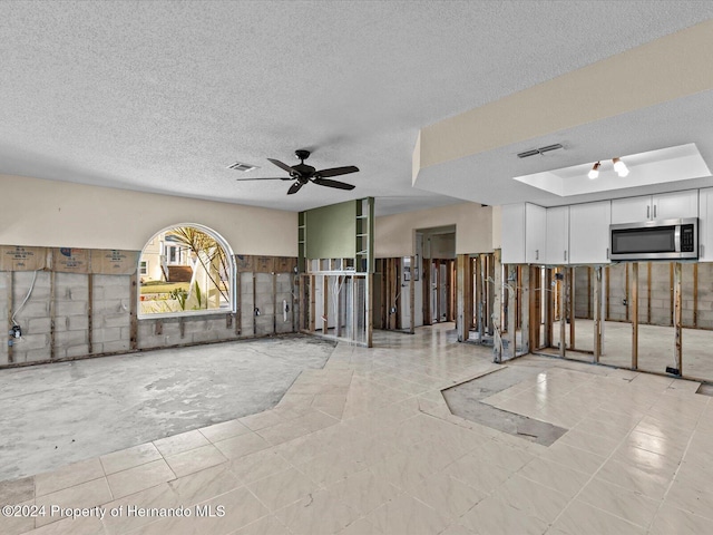 empty room with ceiling fan and a textured ceiling