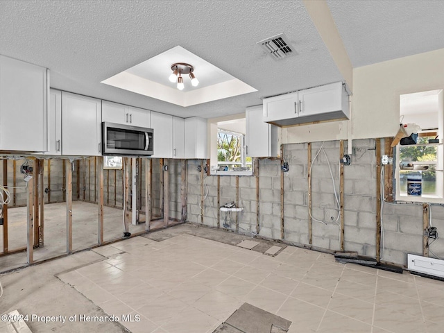 kitchen with white cabinets and a textured ceiling