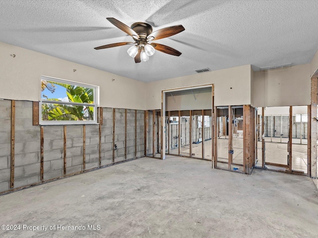 unfurnished room with concrete flooring, a textured ceiling, and ceiling fan