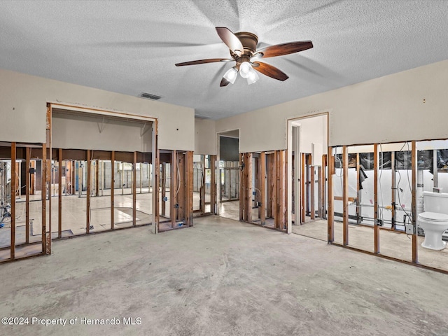 misc room with ceiling fan, concrete flooring, and a textured ceiling