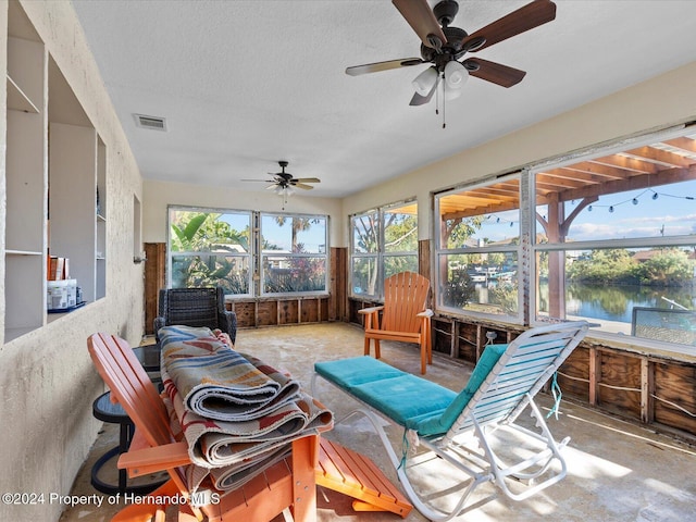 sunroom with a water view and ceiling fan