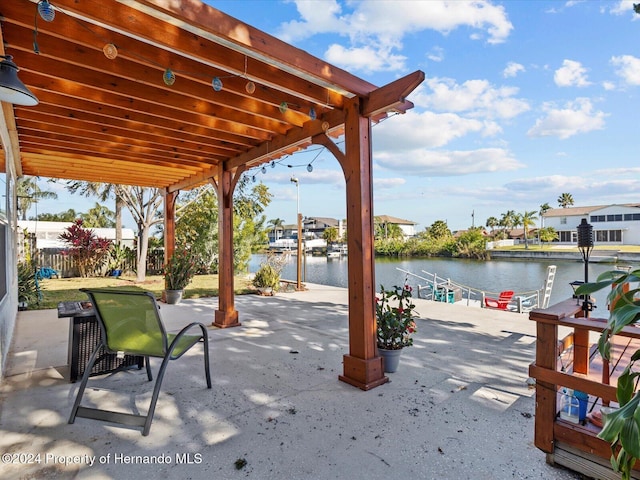 view of patio with a boat dock and a water view