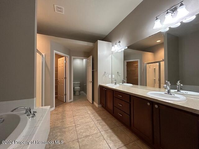 full bathroom with vanity, tile patterned flooring, plus walk in shower, and toilet