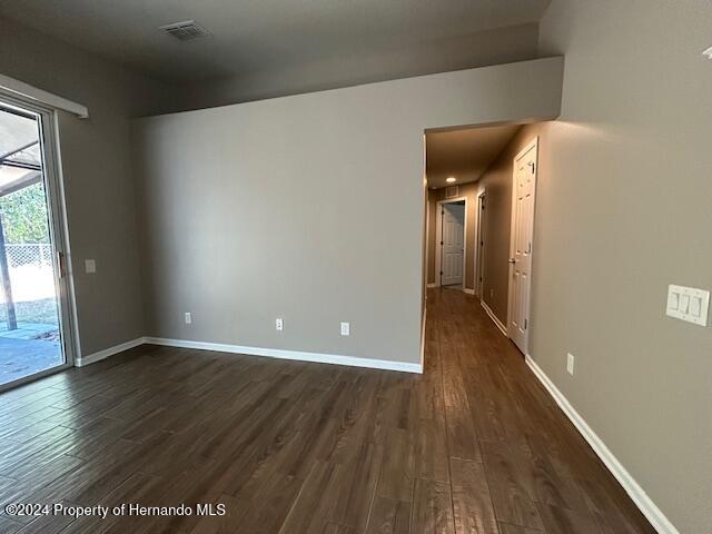 spare room with dark wood-type flooring