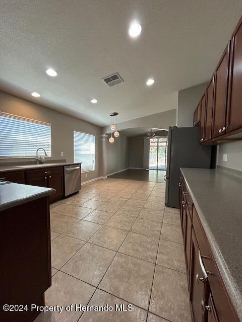 kitchen with ceiling fan, dishwasher, sink, black fridge, and light tile patterned floors