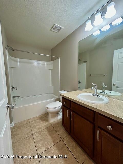 full bathroom featuring visible vents, toilet, tile patterned flooring, a textured ceiling, and vanity