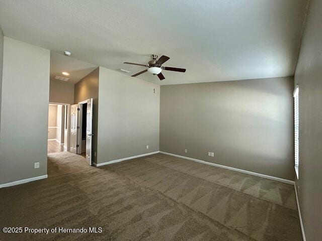 spare room featuring carpet floors, ceiling fan, baseboards, and vaulted ceiling