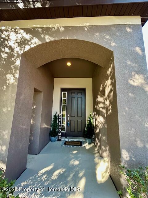 entrance to property with stucco siding