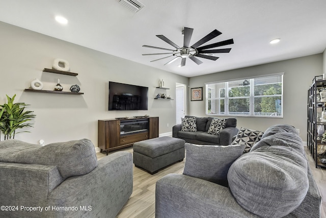 living room featuring light wood-type flooring and ceiling fan