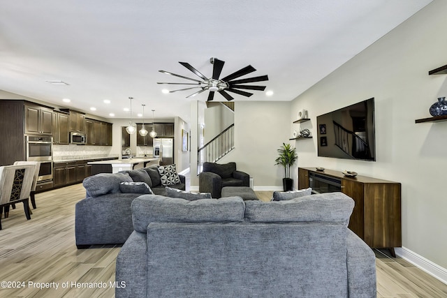 living room with ceiling fan and light hardwood / wood-style floors