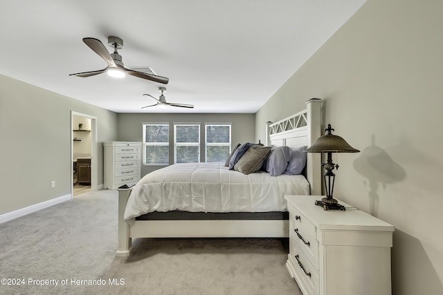 bedroom with light carpet, ensuite bathroom, and ceiling fan