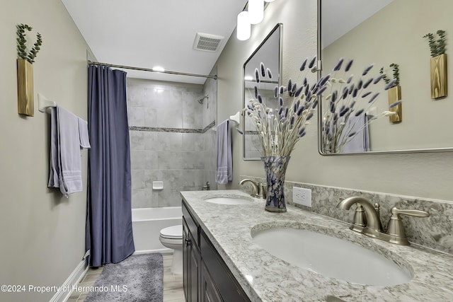 full bathroom featuring hardwood / wood-style flooring, shower / bath combination with curtain, toilet, and vanity