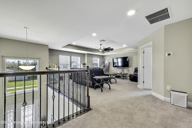 interior space with carpet flooring and a raised ceiling