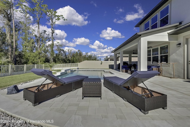 view of swimming pool with outdoor lounge area, ceiling fan, and a patio area