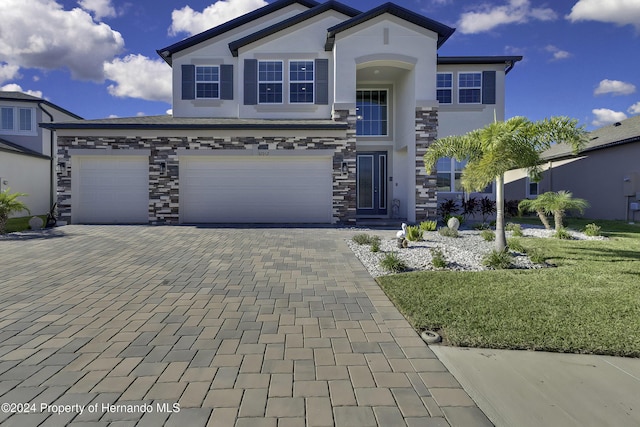 view of front of home with a garage and a front lawn