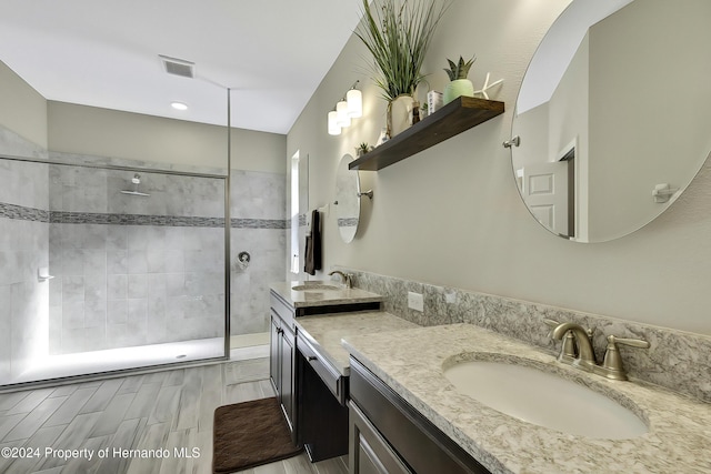 bathroom with a tile shower, hardwood / wood-style floors, and vanity