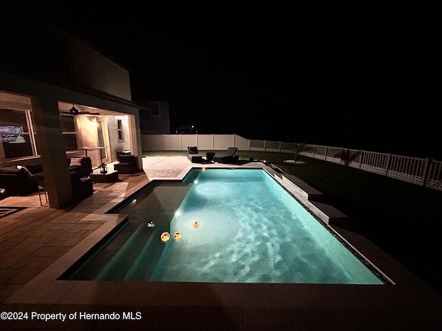 pool at twilight featuring a patio