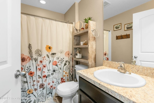 bathroom with vanity, a textured ceiling, and toilet