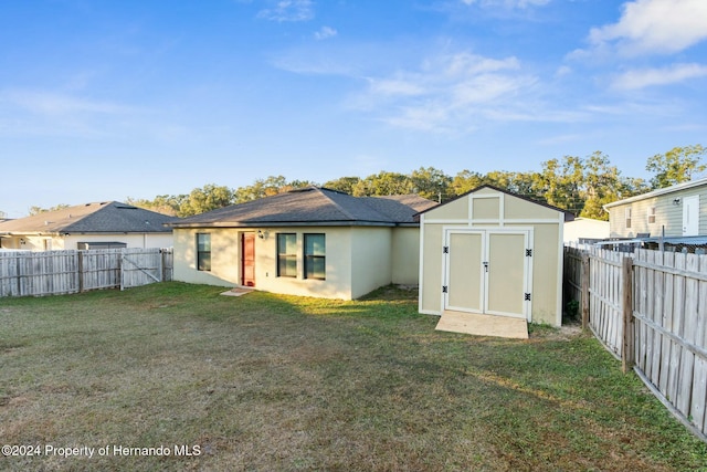 rear view of property with a yard and a shed