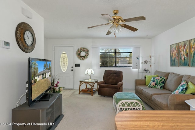 carpeted living room with ceiling fan and a textured ceiling