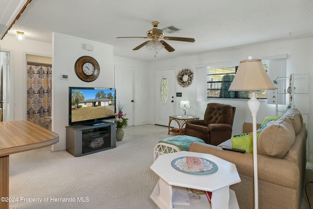 carpeted living room featuring a textured ceiling and ceiling fan