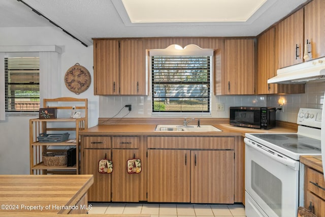 kitchen featuring plenty of natural light, electric stove, and light tile patterned floors