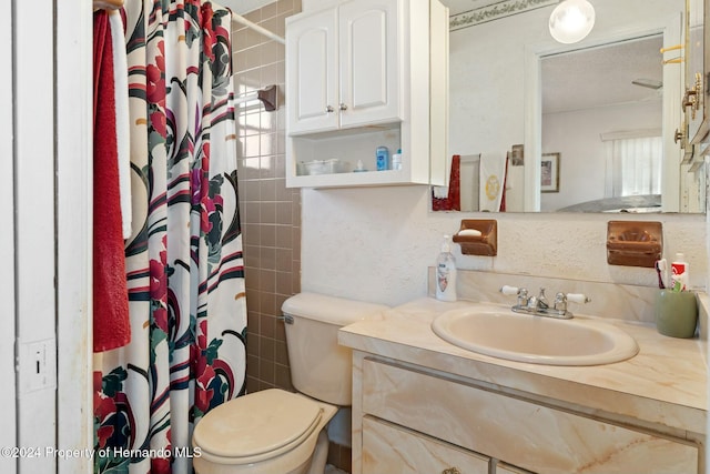 bathroom featuring a textured ceiling, vanity, toilet, and walk in shower