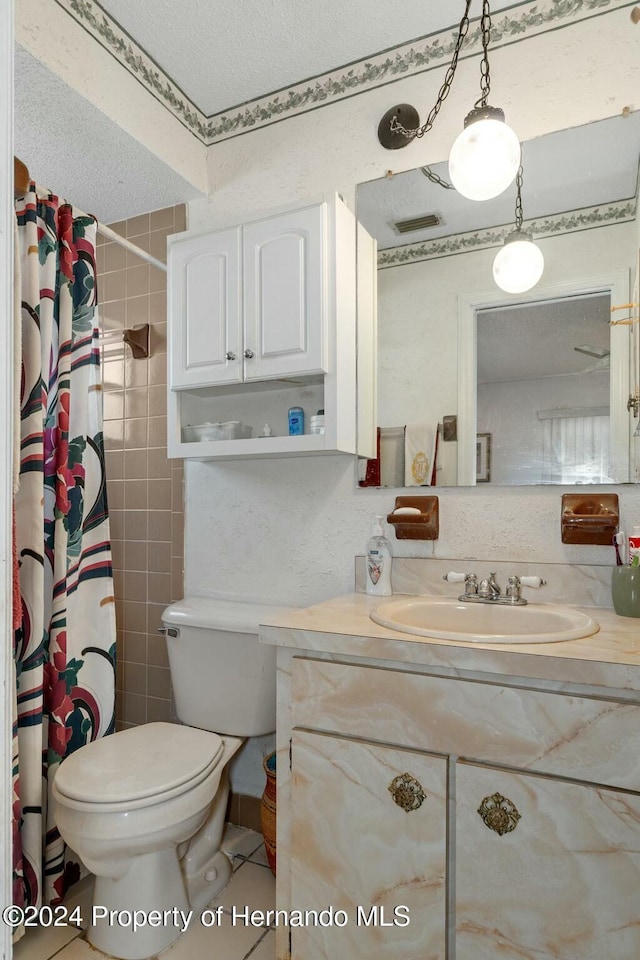 bathroom with a shower with curtain, tile patterned floors, a textured ceiling, toilet, and vanity