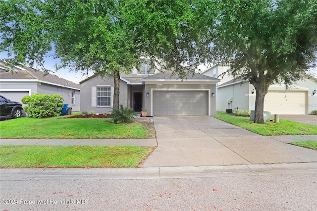 ranch-style house featuring a garage and a front yard