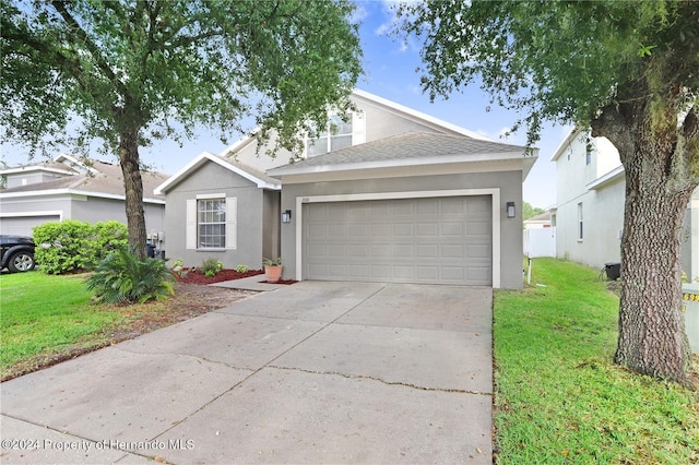 view of front of property with a garage and a front lawn