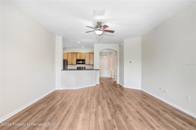 unfurnished living room featuring light hardwood / wood-style floors and ceiling fan