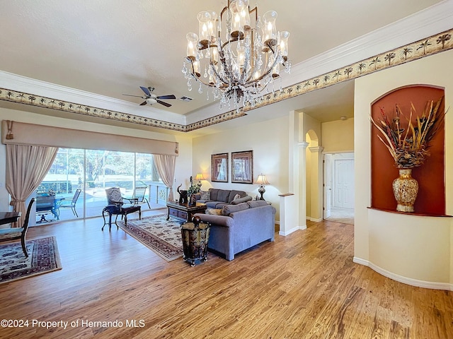 living room featuring ceiling fan with notable chandelier, hardwood / wood-style flooring, and crown molding