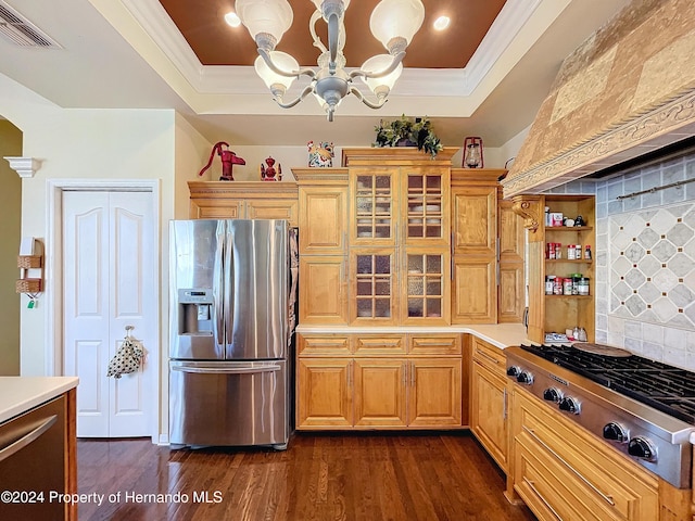 kitchen with a notable chandelier, a raised ceiling, stainless steel appliances, and dark wood-type flooring