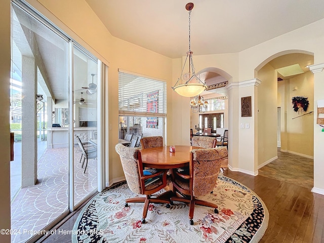 dining space with a healthy amount of sunlight, wood-type flooring, and an inviting chandelier