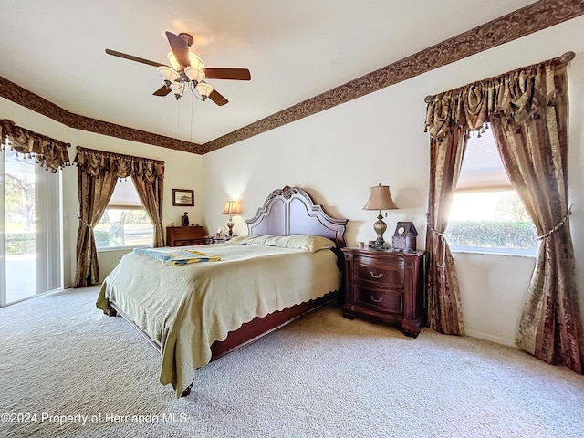 bedroom with access to exterior, light colored carpet, multiple windows, and ceiling fan