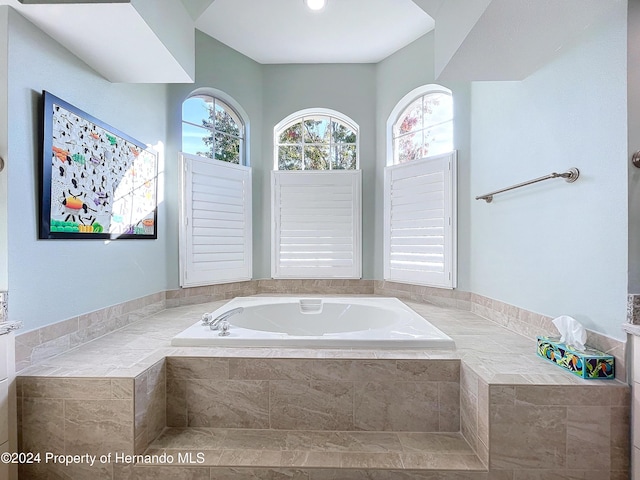 bathroom with tiled bath and a wealth of natural light