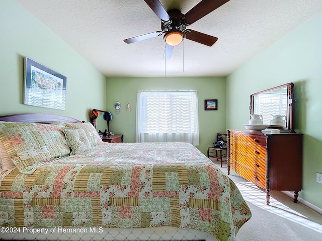 bedroom with light carpet, a textured ceiling, and ceiling fan