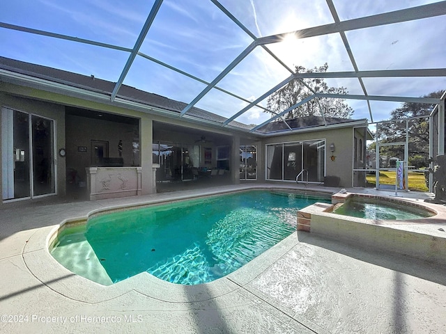 view of swimming pool featuring a lanai, a patio area, and an in ground hot tub