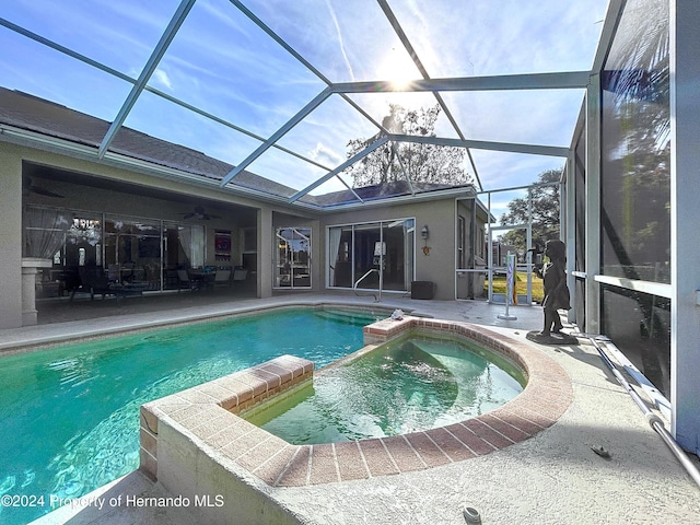 view of pool with a patio area and glass enclosure